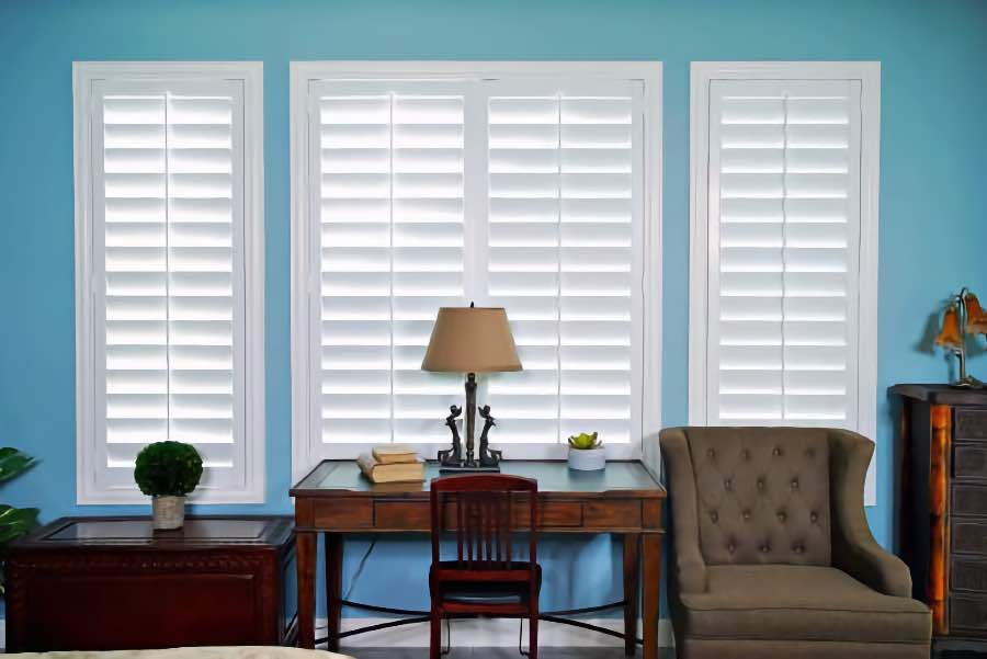 White Polywood shutters in a bedroom with bright blue walls
